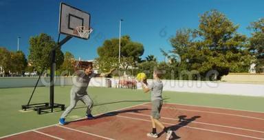 父亲和儿子在户外球场打篮球。